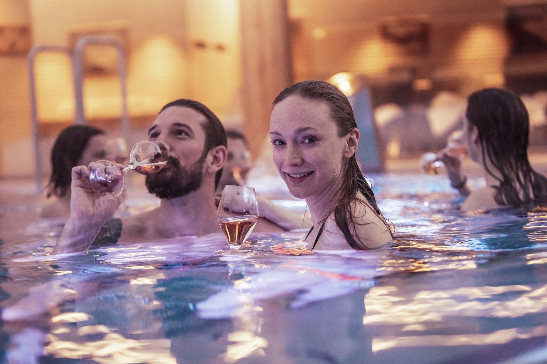Gruppe Freunde geniessen Champagner im Pool. Tirol Lodge - Derek Henthorn - Fotograf München